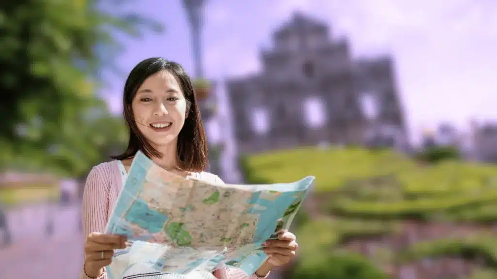 Photo d'une femme en voyage avec une carte d"orientation dans les mains
